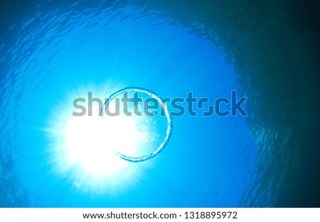 Bubble ring underwater with intense sun rays shining