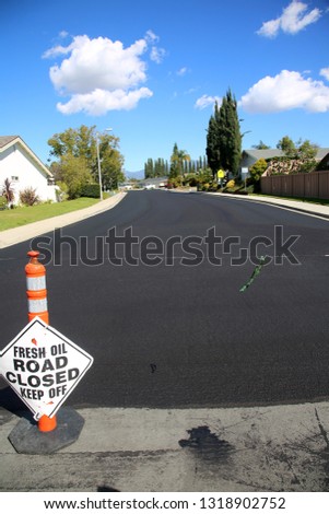 street repair. Fresh slurry or blacktop on surface streets. road work filling pot holes and cracks. fresh oil.  Royalty-Free Stock Photo #1318902752