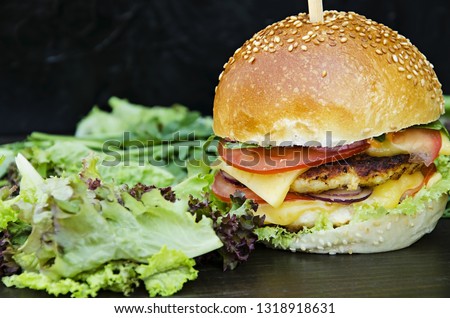 Hamburger burger with chicken cutlet, tomato, cucumber, cheese and lettuce. Fast food.