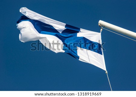 Sunlit Finnish flag flying in the wind
