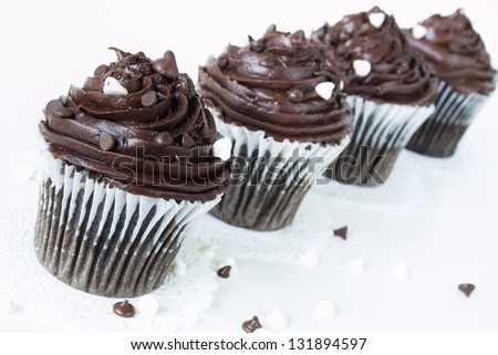 Gourmet quadruple chocolate cupcakes on white background.