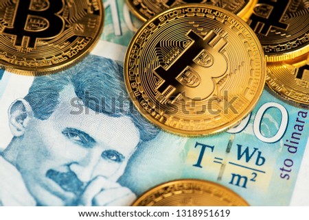 Golden Bitcoin with Serbian banknotes. Portrait of scientist Nikola Tesla. Close up image of bitcoin cryptocurrency with Serbian Dinar banknotes. Serbia Bitcoin