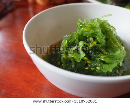 Green seaweed seasoned in Japanese style with white sesame seeds