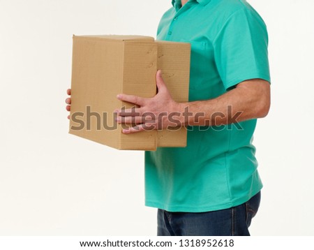 man holds in his hands a big box on a white background.