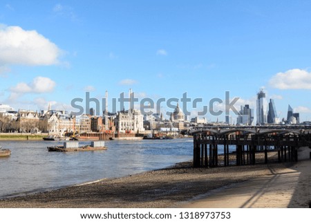 River Thames in London at low tide with exposed sand. View of the city in the background