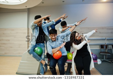 Group of five south asian peoples having rest and fun at bowling club. Holding bowling balls at hands and show dab.