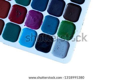 multi-colored watercolor paints close-up on a white isolated background