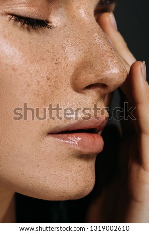 close up view of tender woman with freckles on face isolated on grey Royalty-Free Stock Photo #1319002610