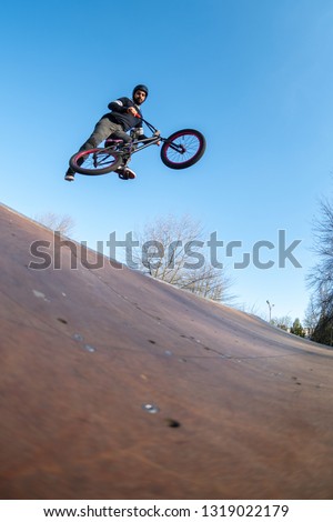 BMX jump in a wooden ramp at skate park.