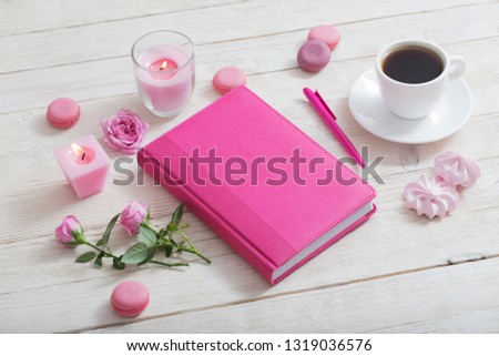 notebook with cup of coffee on white wooden table