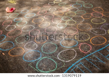 chalk drawing of kid's pictures and color chalks on asphalt.