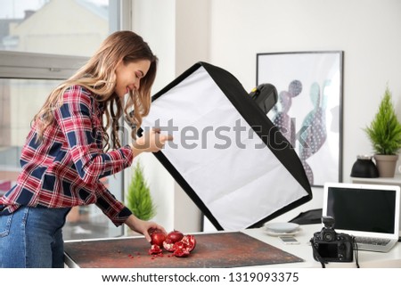 Female food photographer with mobile phone taking picture of fresh studio in home studio