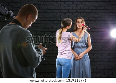 Professional makeup artist working with young model in photo studio