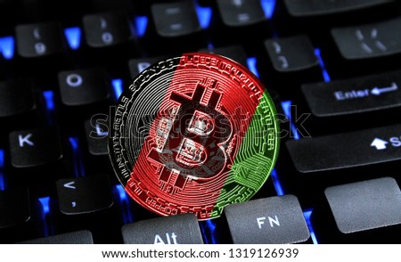 Bitcoin close-up on keyboard background, the flag of Afghanistan is shown on bitcoin.