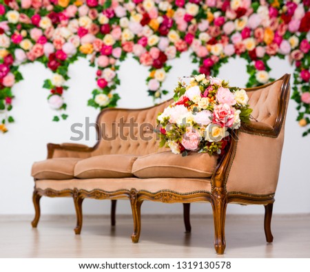 beautiful flowers on vintage sofa over colorful summer flowers wall background