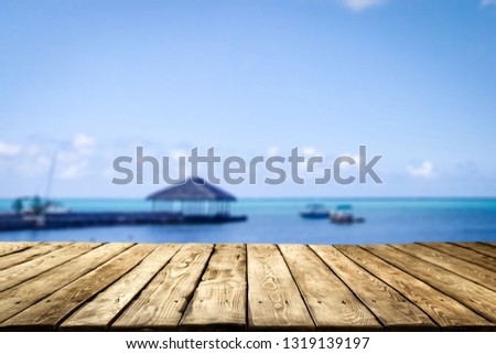 Desk of free space and sea landscape with pier and boats. Blue sky 