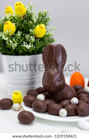Easter background - close up of chocolate Easter bunny, colorful eggs and sweets on the table