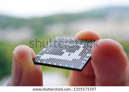 A person finger holding a Ball Grid Array Integrated Circuit or BGA IC. BGA IC is the finest technology for surface mount device
