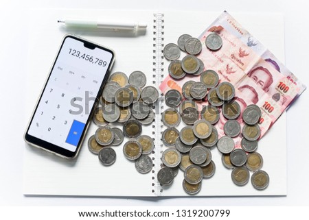 ฺMoney, pile of coin and stack of bank note with calculator and pencil on notebook isolated on white background can be used in article of business and financial