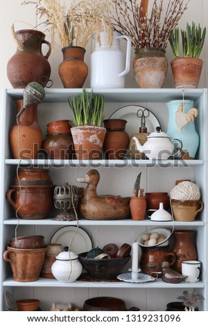 Home Collection of vintage old aged clay, pottery, ceramic finds, authentic dishes, enamel kitchen items, fresh hyacinthine, muscari in flowerpot on wooden shelf, rack, vertical photo, rustic style