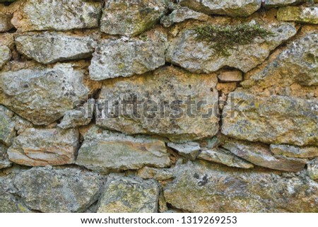 Neatly stacked rough cut stone wall seamless texture background.