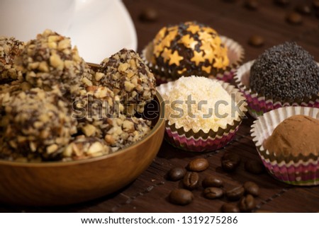Chocolate Sweets Covered with Peanuts, Handmade Candies with Cup of Coffee with Marshmallows on Dark Background. Tasty Luxury Dessert