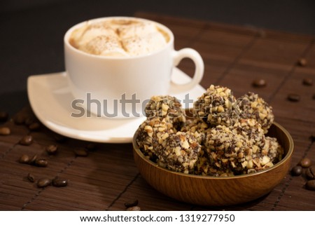 Chocolate Sweets Covered with Peanuts, Handmade Candies with Cup of Coffee with Marshmallows on Dark Background. Tasty Luxury Dessert