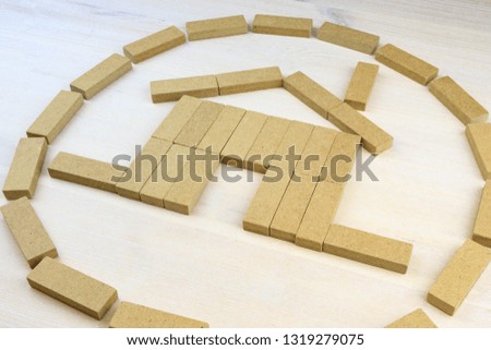 the image of a house with a pipe made of wooden bars, on a wooden light background