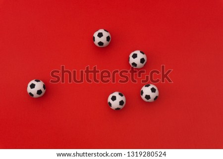 Football balls on red background. Top view. Soccer football field.