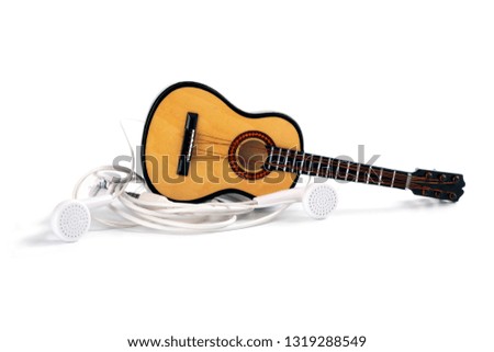 Template for music theme. Concept Dollhouse small acoustic guitar and real headphones as a lifestyle isolated on white background
