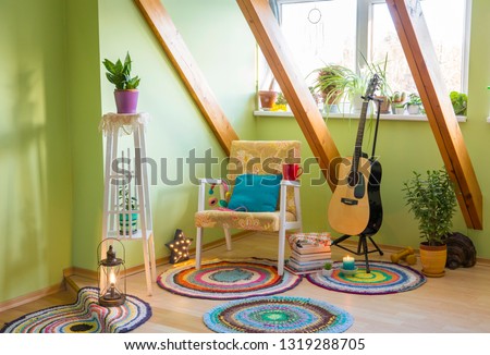 Modern maximalism or maximalist home decor interior design concept, different colorful things in home, vintage chair, flower stand, bright green wall.