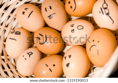Lots of fresh chicken eggs with smiling faces in the basket from the top view. Show your emotions. Organic food ingridients close up. Stay healthy concept.