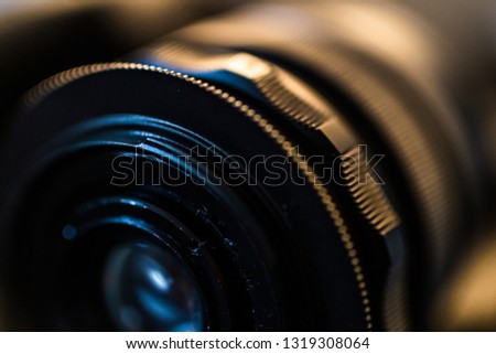 Close up detail of an old vintage lens under warm and cold artificial light with soft focus background 
