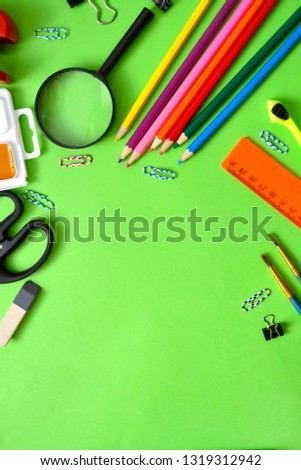 school subjects: pens, notebooks, pencils, paper clips on a light green background