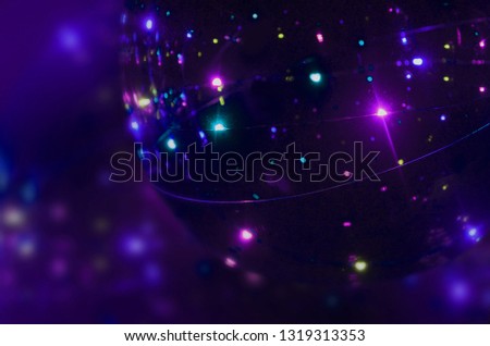 Abstract blurred dark purple blue background with silver, white bokeh and flashes of light. Image