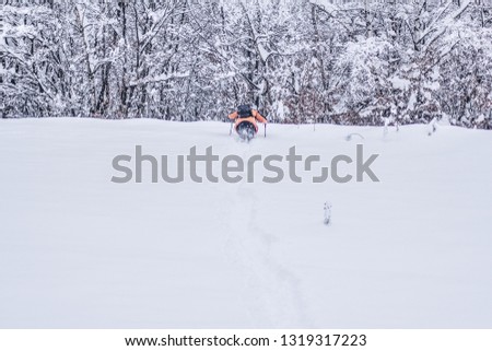 Man is hiking in snowy winter mountains with hiking equipment