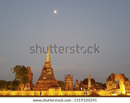 Full Moon over the temple at Ayuthaya, Thailand. There are many visitors taking photos during visiting Ayuthaya Historical Park.