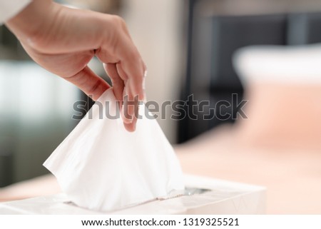 women hand picking napkin/tissue paper from the tissue box Royalty-Free Stock Photo #1319325521