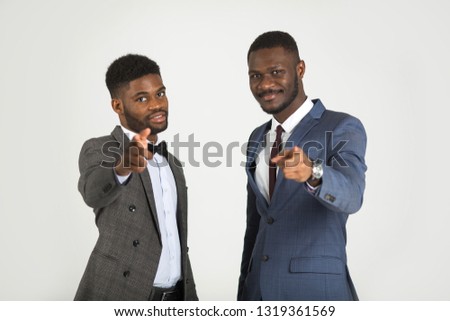 two stylish men in suits on gray background with hand gesture