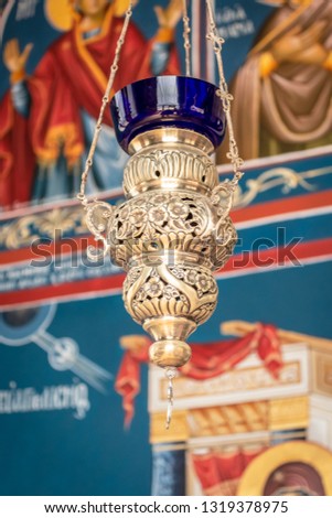 Gilded lamp in the church on the background of icons. The background is blurred.
