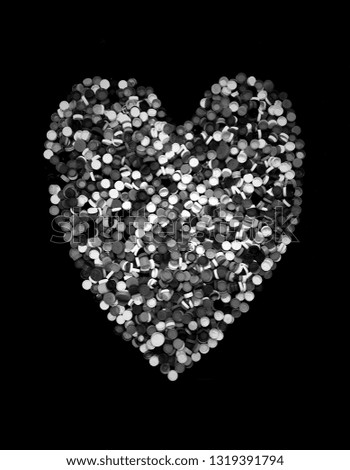 The reused cap of many bottle of water formed to be a recycle shape of heart. This mean loving and caring for nature (reused plastic cap), Take a picture of a black and white tone.