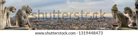 Chimeras (gargoyles) on the Cathedral of Notre Dame de Paris overlooking Paris panorama, France. Focus on the sculptures, blurred city. Perfect background for design or text
