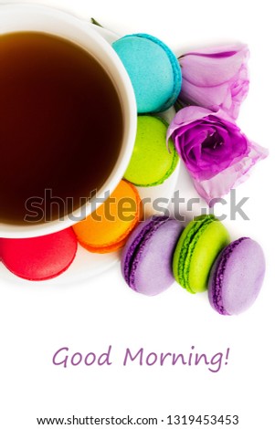 Cake macaron or macaroon on white plate with cup of coffee isolated on white, colorful almond cookies, pastel colors, violet spring flower. Top view with text good morning.