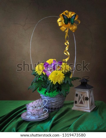 Still life with basket of yellow chrysanthemums and purple orchids