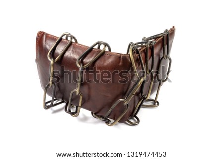 Brown leather wallet bound by an old metal chain on white in a conceptual image of monetary security or controlling spending