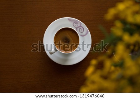 Coffee with mimosa blossom flower on dark background