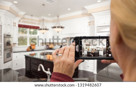 Woman Taking Pictures of A Custom Kitchen with Her Smart Phone.