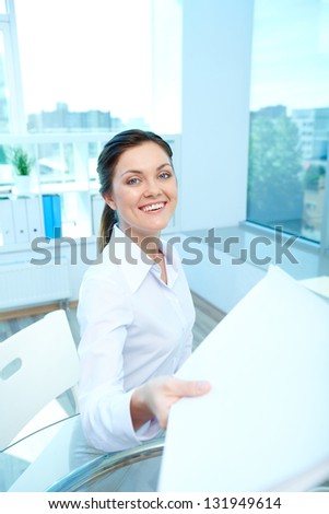 Portrait of young smiling female giving application to conductor