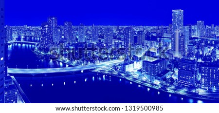 Duotone vibrant aerial view of night Tokyo panorama with skyscrapers, Sumida river and illuminated bridges with water reflections