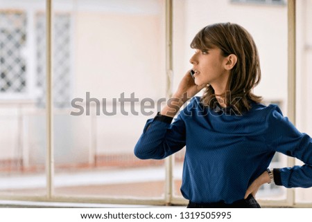 Young businesswoman speaks on her cell phone in an office.
